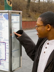 Young student reading a bus schedule